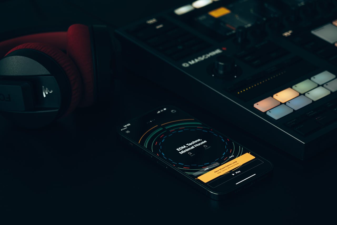 gallery-3 Dark-themed music setup featuring a DJ controller, smartphone, and headphones on a sleek surface.