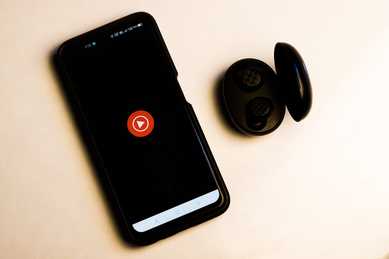 gallery-2 Flat lay of a smartphone and wireless earbuds on a neutral background, ideal for tech and lifestyle themes.
